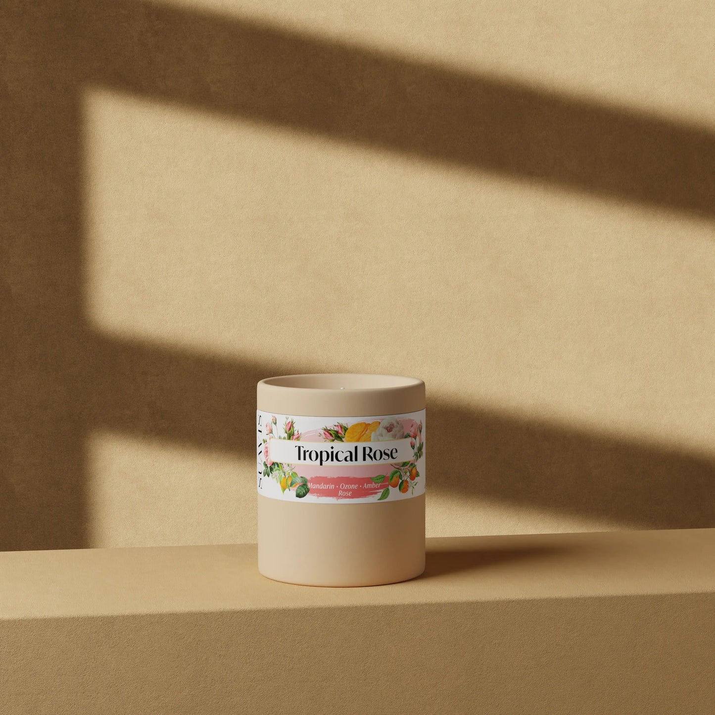 Tropical Rose Scented Candle in a 12oz Cream Ceramic vessel in front of a wall.