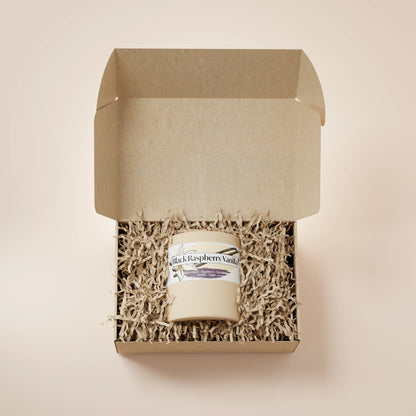 Cream Ceramic 12oz Black Raspberry Vanilla Scented Candle in a box with crinkle paper.