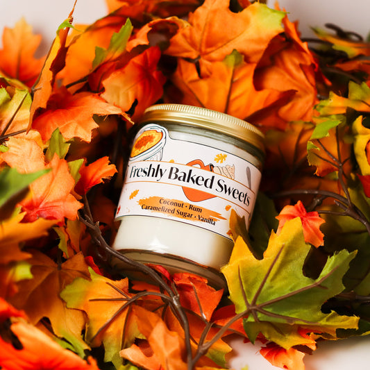 Jar of freshly baked sweets candle surrounded by autumn leaves