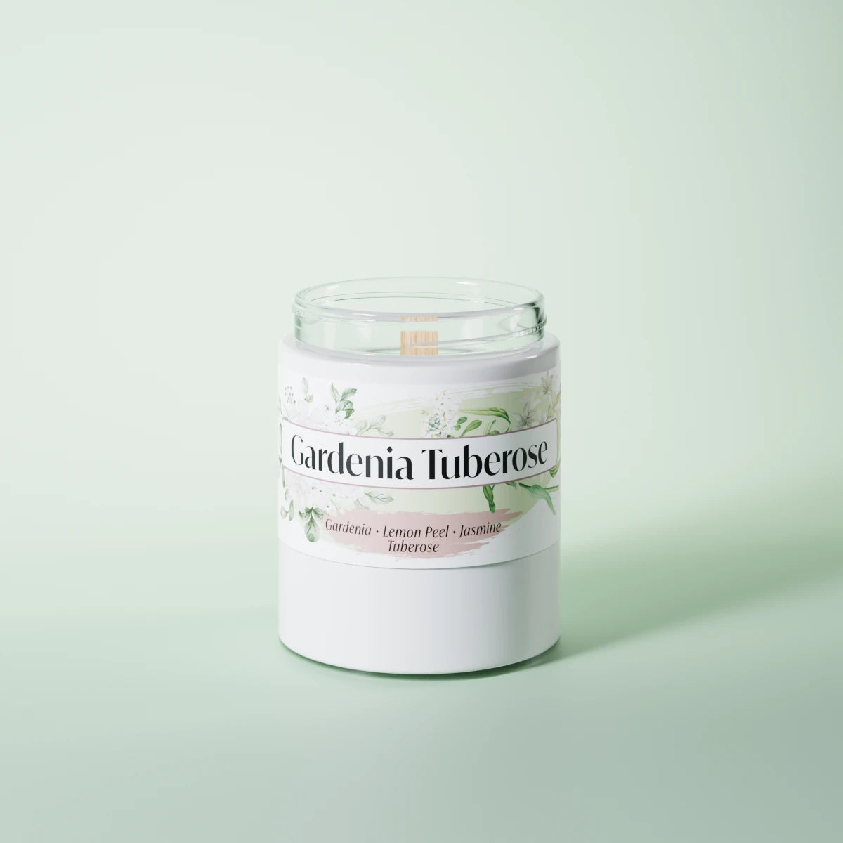 Gardenia Tuberose scented candle in a glass vessel on a light-green studio background