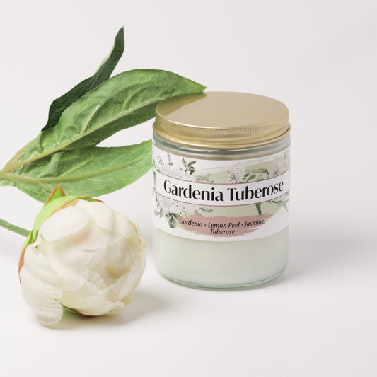 Gardenia tuberose candle on a white background next to a flower