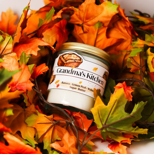 Jar of grandma's kitchen candle surrounded by autumn leaves