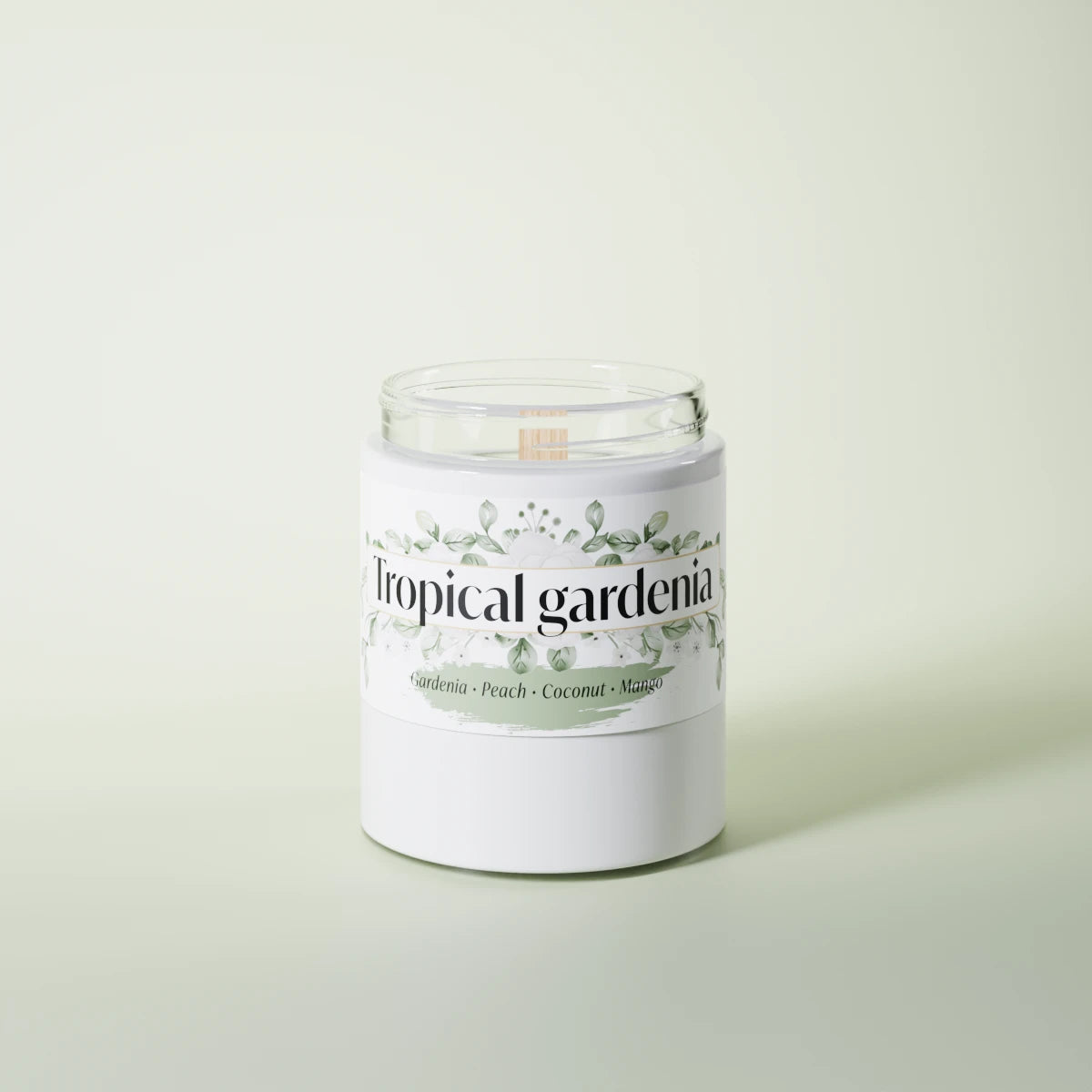 Tropical Gardenia scented candle in a glass vessel on a light-green studio background