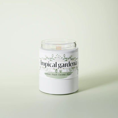 Tropical Gardenia scented candle in a glass vessel on a light-green studio background