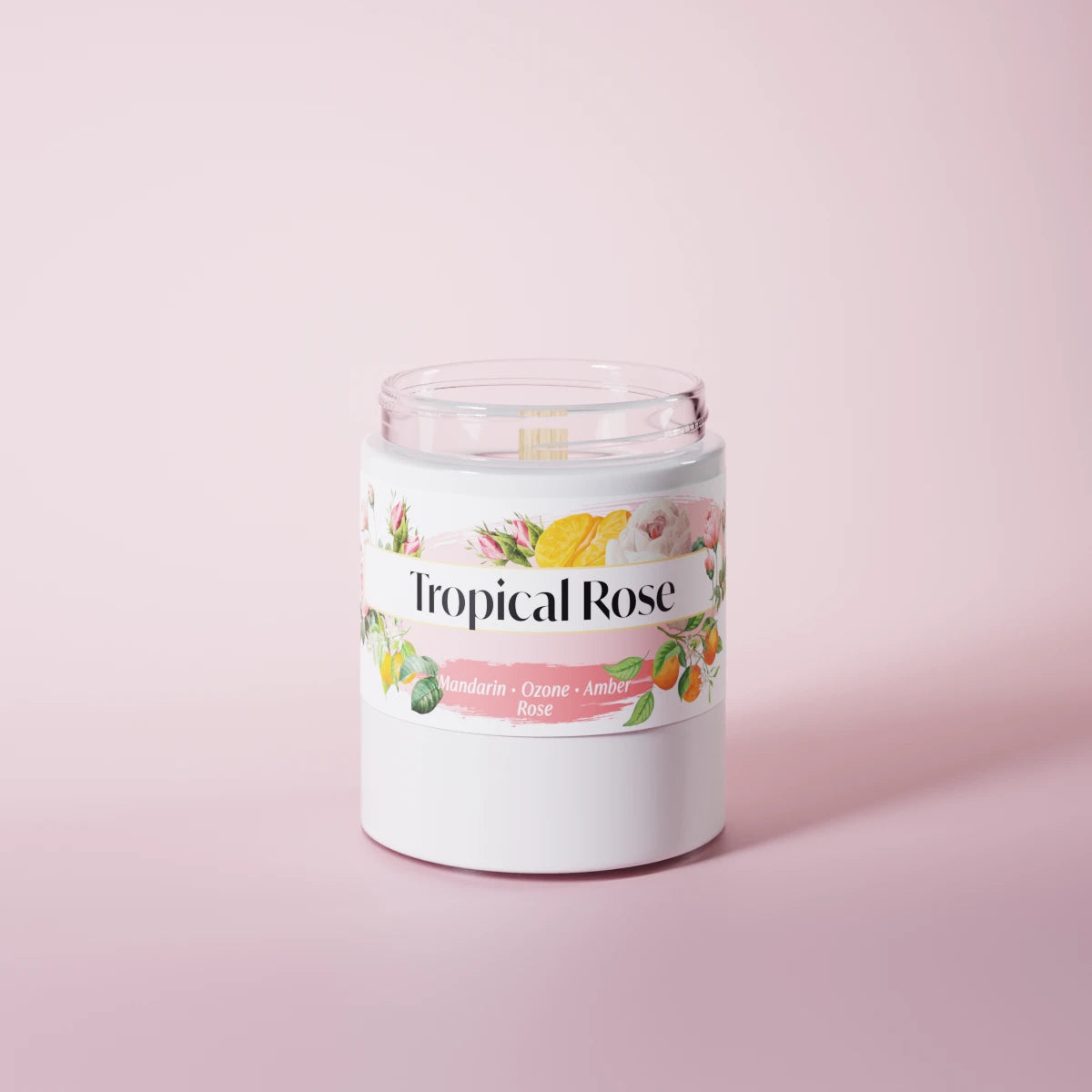 Tropical Rose scented candle in a glass vessel on a pink studio background