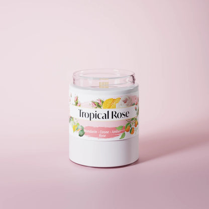 Tropical Rose scented candle in a glass vessel on a pink studio background
