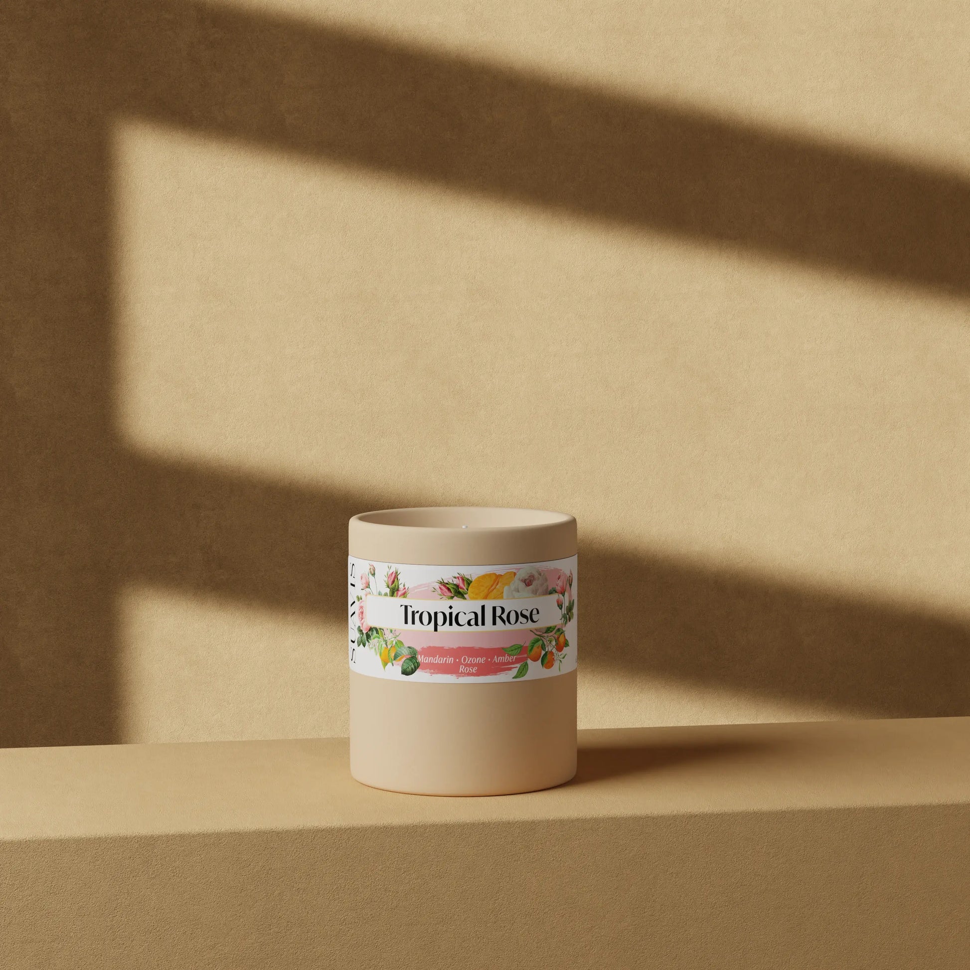 Tropical Rose Scented Candle in a 12oz Cream Ceramic vessel in front of a wall.