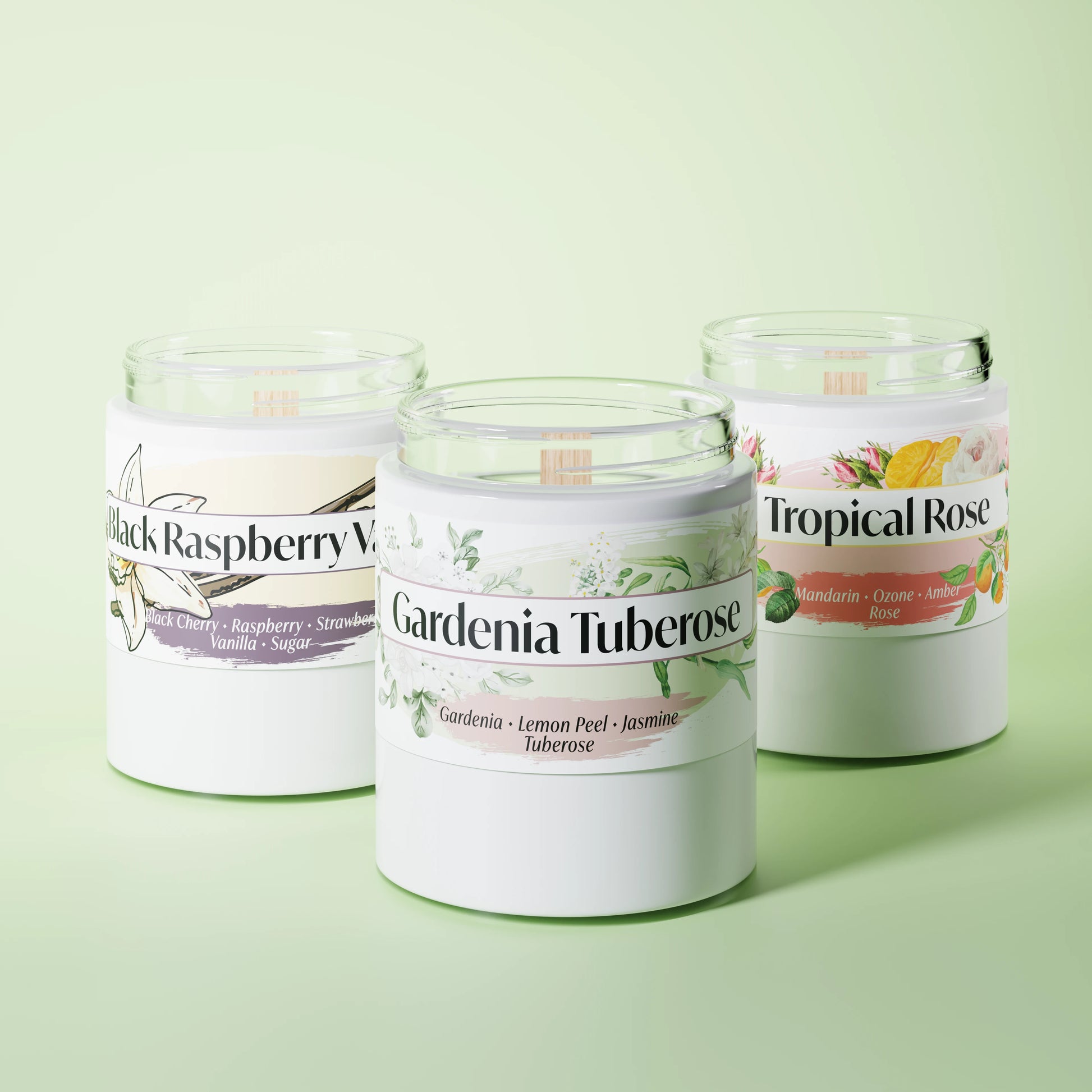 Three scented candles in glass vessels on a light green studio background